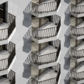 Fassade eines modernen Mehrfamilienhauses mit zahlreichen Balkonen und Metallgeländern